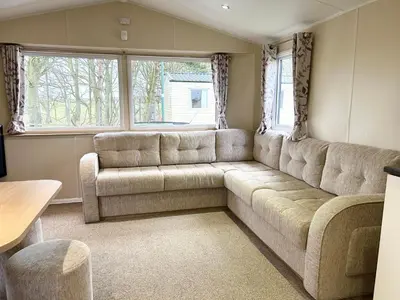 a living room with a couch and a table at The SandyBel Caravan in Cark