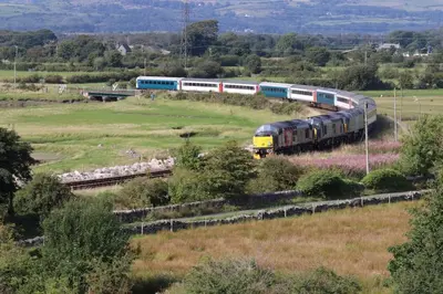 a train traveling down the tracks in a field at Halsteads: peaceful location, stunning views in Soutergate