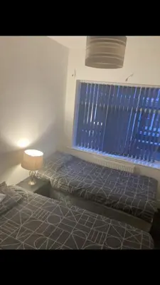a bedroom with a bed and a blue window at Danny holiday home in Blackpool