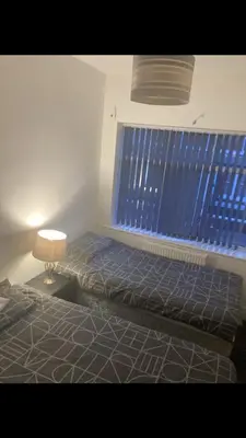 a bedroom with a bed with a window and a lamp at Danny holiday home in Blackpool