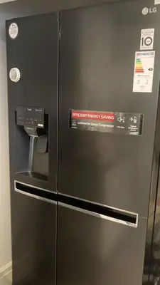 a black refrigerator with a sign on it at Danny holiday home in Blackpool