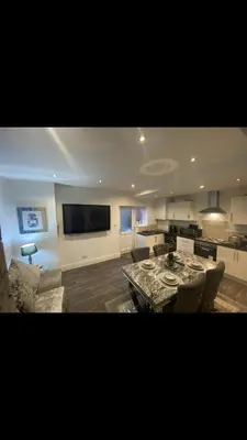 a large kitchen and living room with a table at Danny holiday home in Blackpool