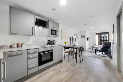 a kitchen with white cabinets and a table with chairs at Host & Stay - The Roscoe Nest in Liverpool