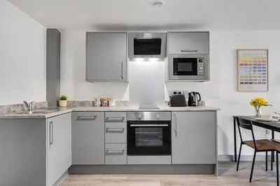 a kitchen with stainless steel appliances and a table at Host & Stay - The Roscoe Nest in Liverpool