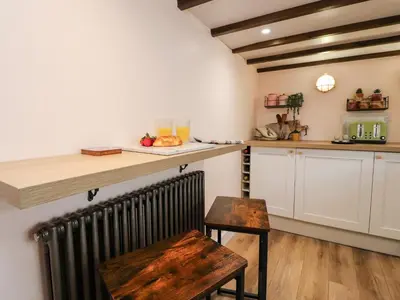 a kitchen with a counter and a table and a radiator at Tilly's Place in Heysham