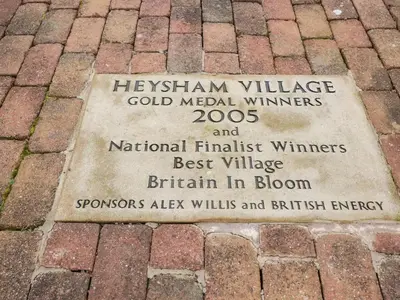 a plaque on a brick sidewalk with the name of theigham at Tilly's Place in Heysham