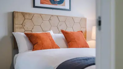 a bedroom with a bed with orange and white pillows at Host & Stay - The Baltic Penthouse 2 in Liverpool
