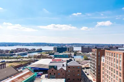a view of a city with a river and buildings at Host & Stay - The Baltic Penthouse 2 in Liverpool
