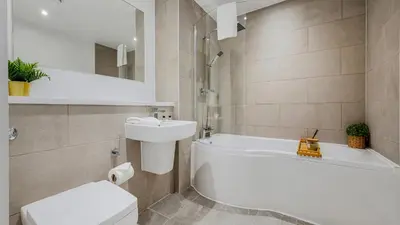 a bathroom with a tub and a toilet and a sink at Host & Stay - The Baltic Penthouse 2 in Liverpool