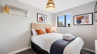 a bedroom with a bed and two windows at Host & Stay - The Baltic Penthouse 2 in Liverpool