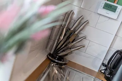 a bunch of utensils sitting on a counter next to a clock at Charles Alexander Short Stay - Botanical House in Cleveleys