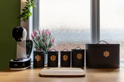a group of four black containers on a table with a blender at Charles Alexander Short Stay - Botanical House in Cleveleys