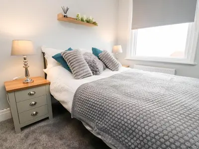 a bedroom with a bed with pillows and a window at Ferry View in Fleetwood