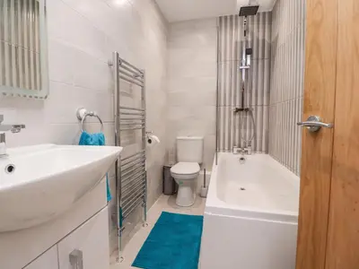 a bathroom with a sink and a tub and a toilet at Ferry View in Fleetwood