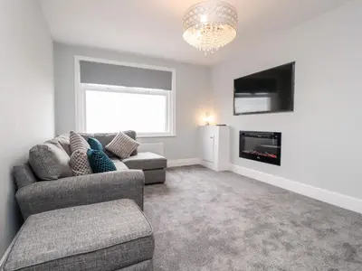 a living room with a couch and a tv at Ferry View in Fleetwood