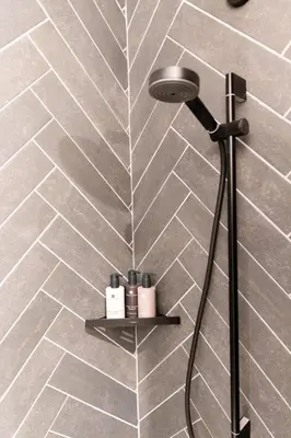 a shower in a bathroom with a tile wall at School Lane Hotel in Liverpool ONE in Liverpool