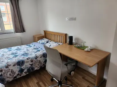 a bedroom with a desk and a bed with a bed gmaxwell gmaxwell at Jey's Flat in Liverpool