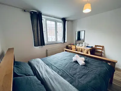 a bedroom with a large bed and a window at Jey's Flat in Liverpool