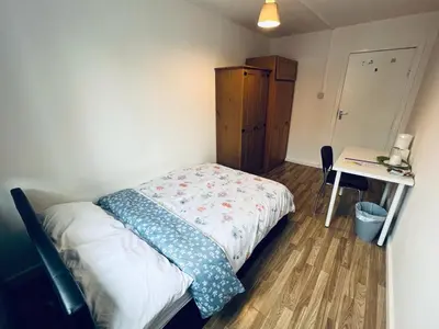 a small bedroom with a bed and a desk at Jey's Flat in Liverpool