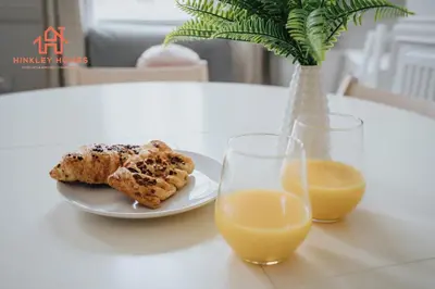 a table with a plate of food and a glass of orange juice at Large City Centre Apartment - Georgian Townhouse- Rodney St in Liverpool