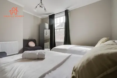 a white bedroom with two beds and a window at Large City Centre Apartment - Georgian Townhouse- Rodney St in Liverpool