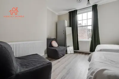 a bedroom with a bed and a chair and a window at Large City Centre Apartment - Georgian Townhouse- Rodney St in Liverpool