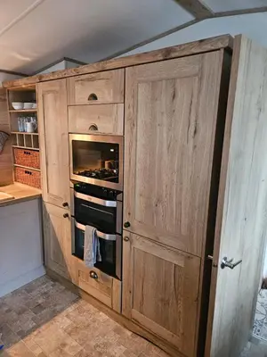 a kitchen with wooden cabinets and an oven at Roadnights Retreat in Heysham