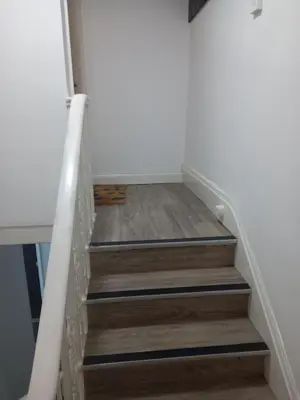 a staircase with wooden floors and white walls at Flat 4, 43 Part Street in Southport