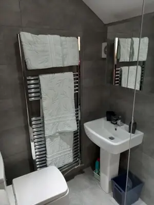 a bathroom with a sink and a toilet and towels at Flat 4, 43 Part Street in Southport