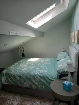 a bedroom with a bed with a green comforter at Flat 4, 43 Part Street in Southport