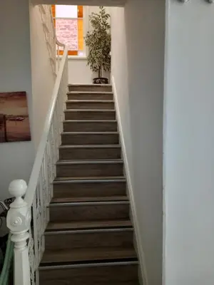 a staircase in a home with white walls and wooden floors at Flat 4, 43 Part Street in Southport
