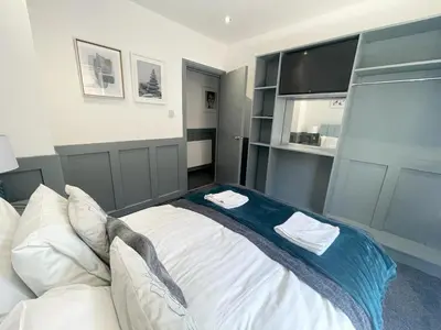 a bedroom with a large bed and a tv at Olivia Rose Suite by Sasco Apartments in Blackpool