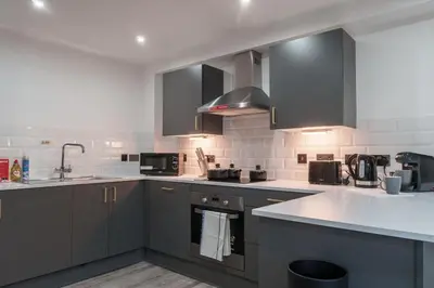 a kitchen with stainless steel appliances and gray cabinets at Lovely 1 Bedroom Apartment in Preston in Preston