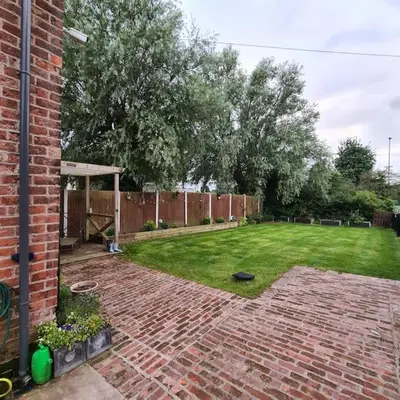 a backyard with a brick yard with a grassy yard at The Coach House in Blackpool