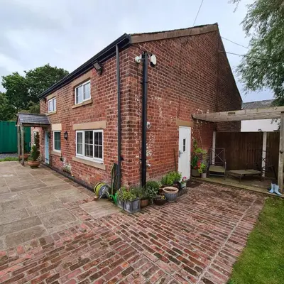 a brick house with a brick patio at The Coach House in Blackpool