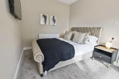 a bedroom with a large bed and a television at The Park Road Suites by Central Beach Leisure in Blackpool