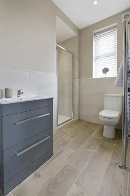 a bathroom with a sink and a toilet and a shower at The Park Road Suites by Central Beach Leisure in Blackpool