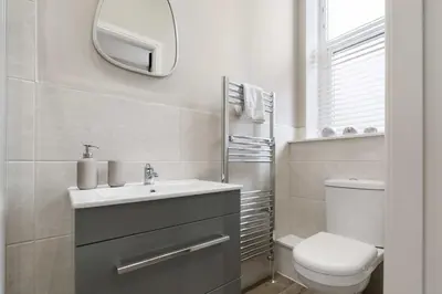 a bathroom with a sink and a toilet and a mirror at The Park Road Suites by Central Beach Leisure in Blackpool