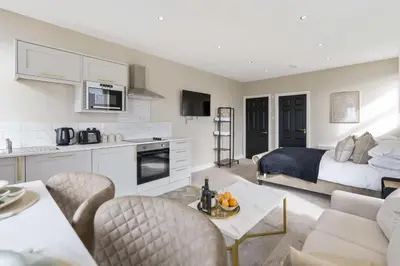 a kitchen and living room with a bed and a living room at The Park Road Suites by Central Beach Leisure in Blackpool