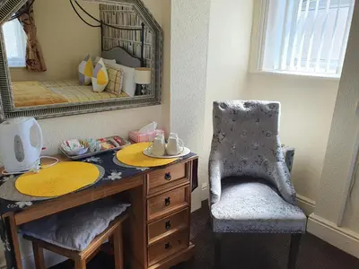 a bedroom with a desk and a chair and a mirror at Windsor House Hotel in Blackpool