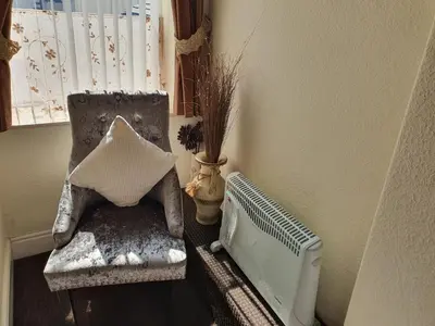 a living room with a chair and a radiator at Windsor House Hotel in Blackpool