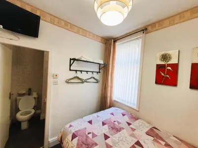 a bedroom with a bed and a window and a toilet at Windsor House Hotel in Blackpool