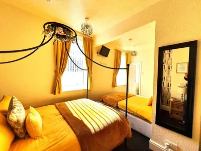 a hotel room with two beds and a mirror at Windsor House Hotel in Blackpool