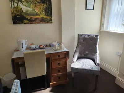 a desk with a chair and a dresser in a room at Windsor House Hotel in Blackpool