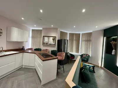 a kitchen and living room with a couch and a table at Strawberry Fields Suite by Sasco Apartments in Blackpool