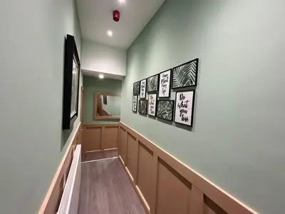 a hallway with several pictures on the wall at Strawberry Fields Suite by Sasco Apartments in Blackpool