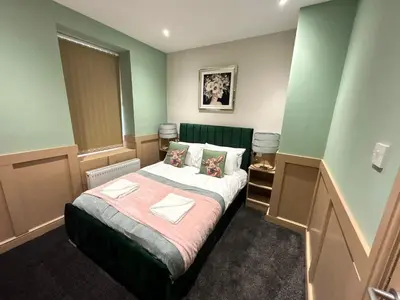a bedroom with a bed in a room with green walls at Strawberry Fields Suite by Sasco Apartments in Blackpool