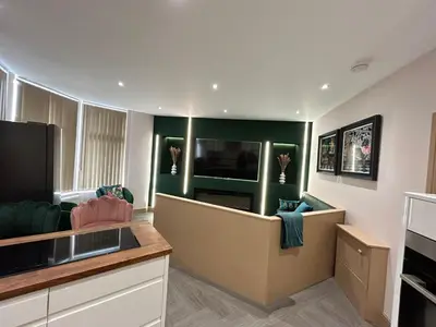 a living room with a couch and a tv at Strawberry Fields Suite by Sasco Apartments in Blackpool