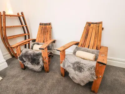 a couple of rocking chairs sitting next to a wall at Anandom in Blackpool