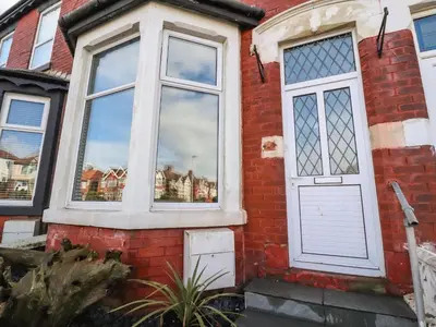 a brick house with a white door and windows at Anandom in Blackpool